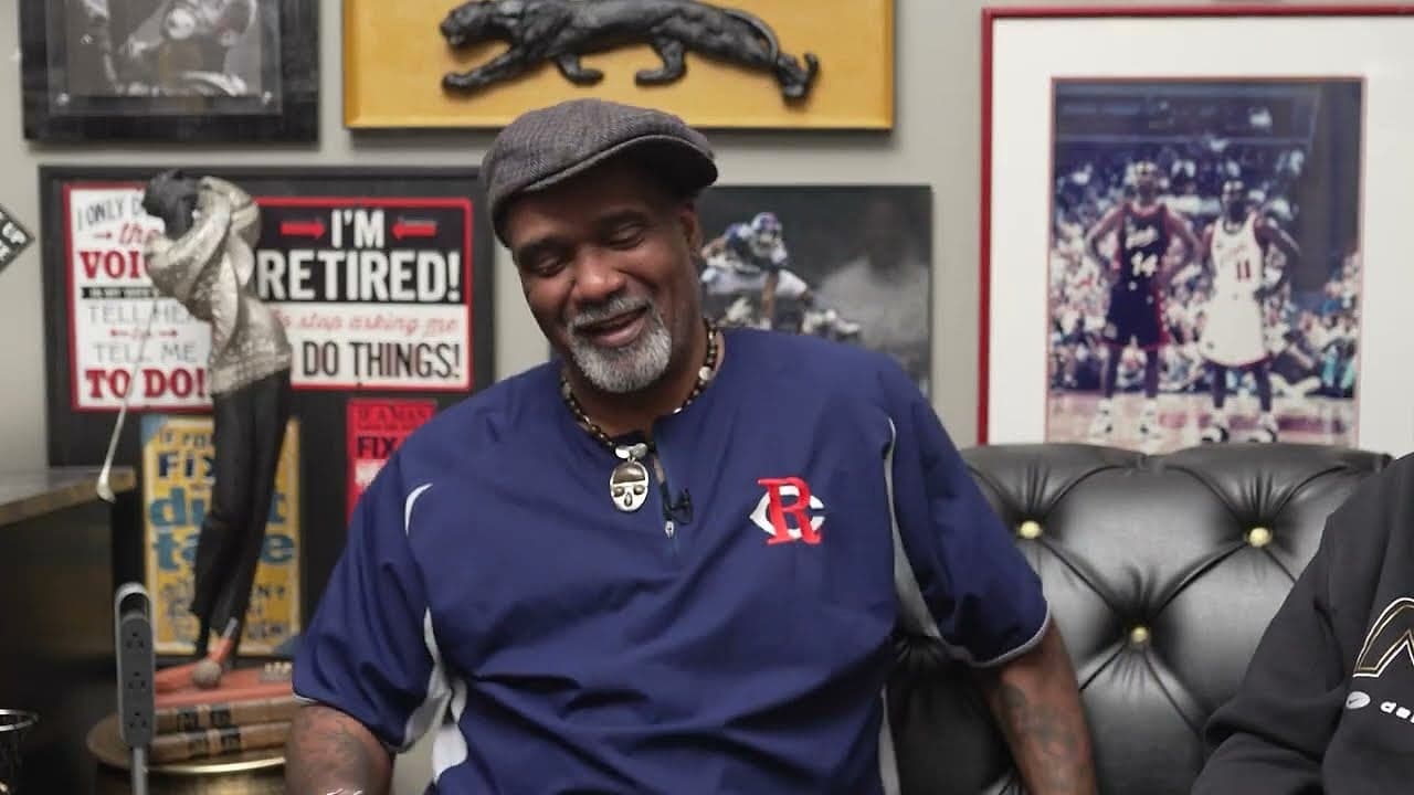 A barbershop regular grinning under his cap
