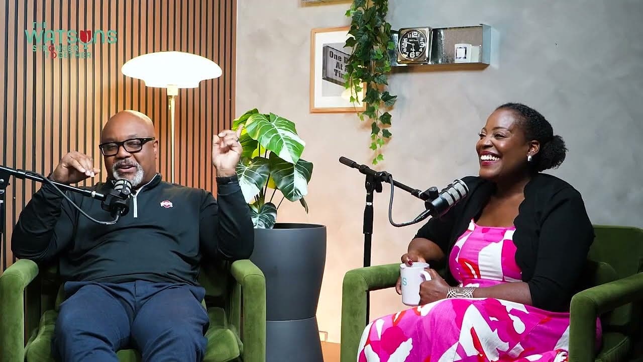 A host and guest laughing in green armchairs