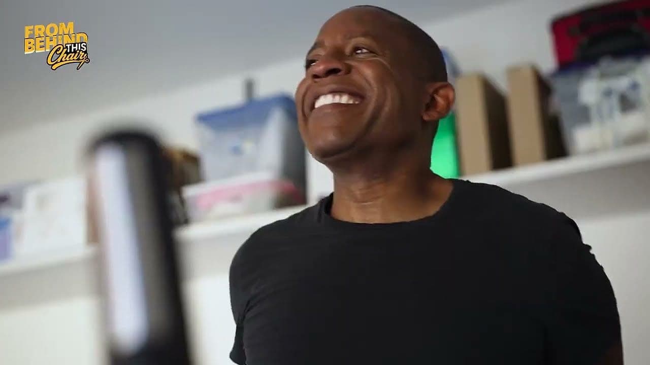 A guest throwing his head back laughing in the barbershop